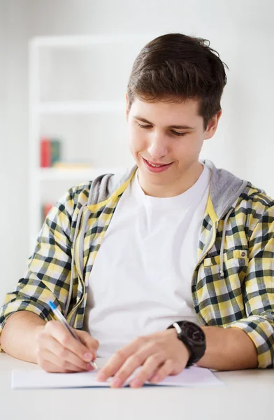 Lächelnder Schüler mit Schulbüchern in der Schule — Stockfoto