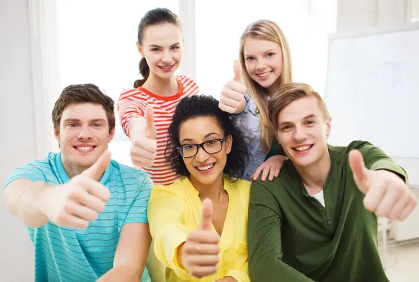 Lachende studenten op school duimen opdagen — Stockfoto