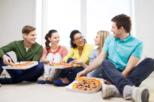 Cinco adolescentes sorrindo comendo pizza em casa — Fotografia de Stock