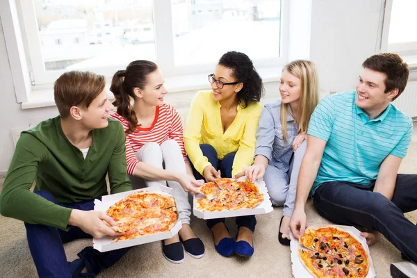 Cinco adolescentes sorrindo comendo pizza em casa — Fotografia de Stock