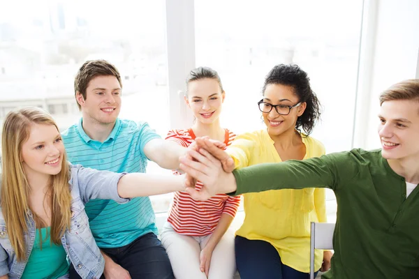 Smiling students making high five gesture sitting — Stock Photo, Image