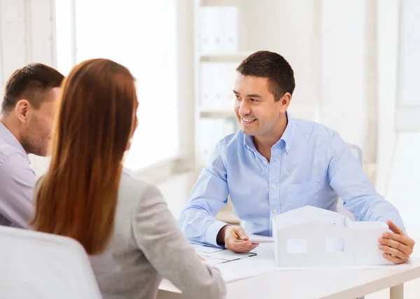 Pareja mirando el modelo de su casa en la oficina — Foto de Stock