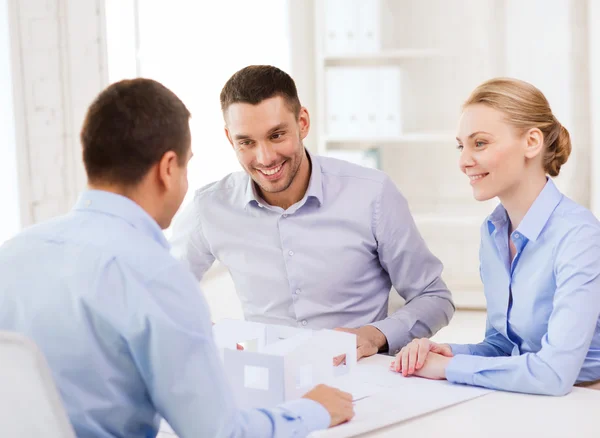 Couple looking at model of their house at office — Stock Photo, Image