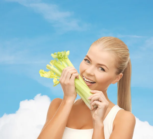 Женщина кусает кусок сельдерея или зеленый салат — стоковое фото