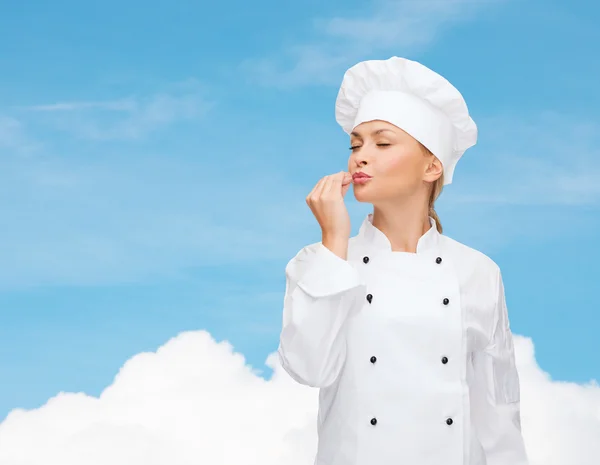 Glimlachend vrouwelijke chef-kok heerlijke teken weergegeven: — Stockfoto