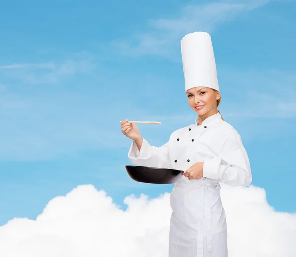 Lachende vrouwelijke chef-kok met pan- en -lepel — Stockfoto