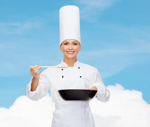 Lachende vrouwelijke chef-kok met pan- en -lepel — Stockfoto