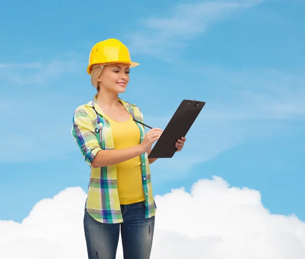 Smiling woman in helmet with clipboard — Stock Photo, Image