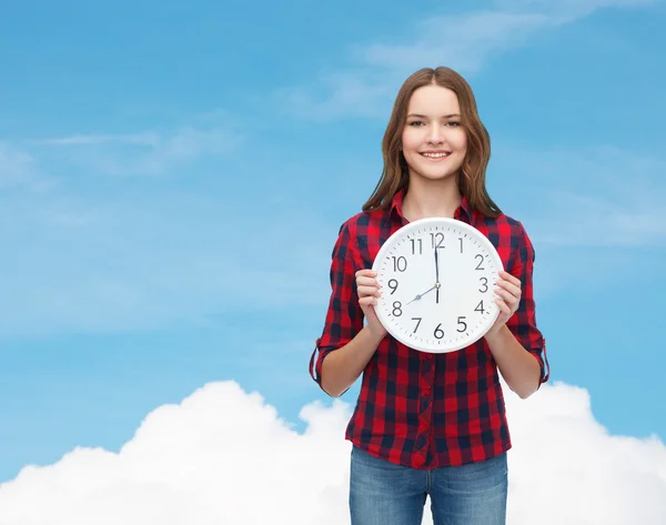 Young woman in casual clothes with wall clock — Stock Photo, Image