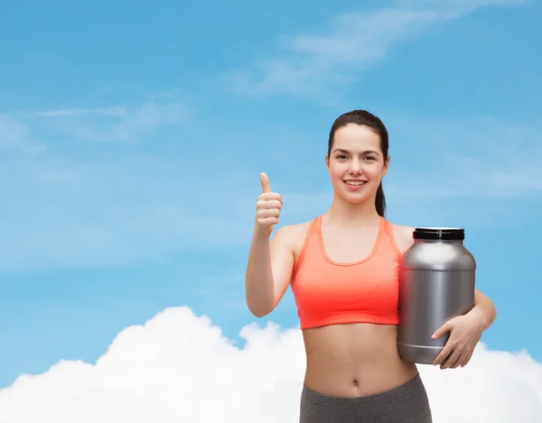 Adolescente con tarro de proteína mostrando los pulgares hacia arriba — Foto de Stock