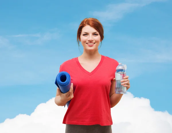 Chica sonriente con botella de agua después de hacer ejercicio —  Fotos de Stock