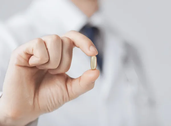 Doctor hand showing one capsule — Stock Photo, Image