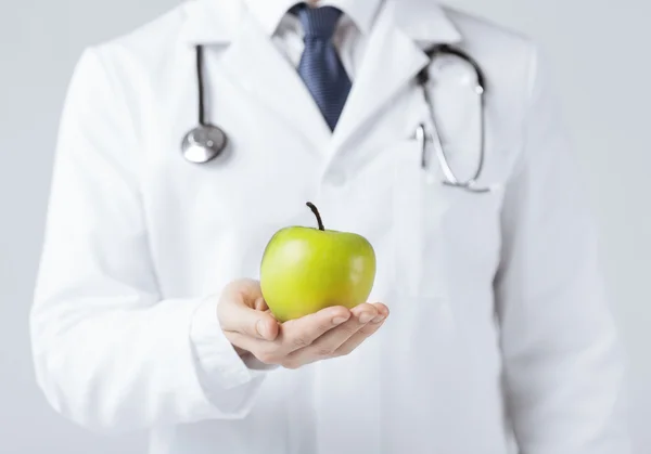 Мужской врач с зеленым яблоком — стоковое фото