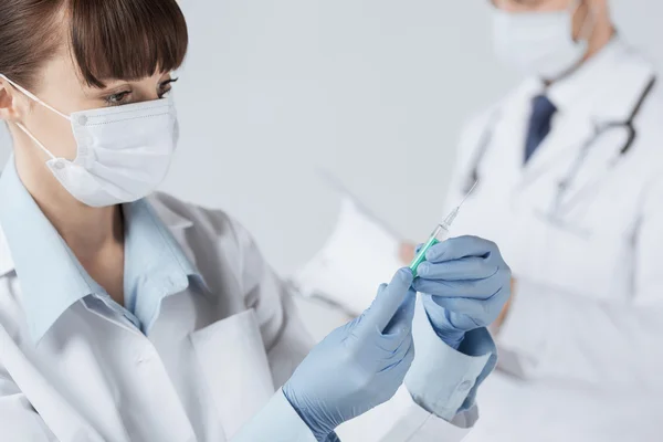 Médico fêmea segurando seringa com injeção — Fotografia de Stock