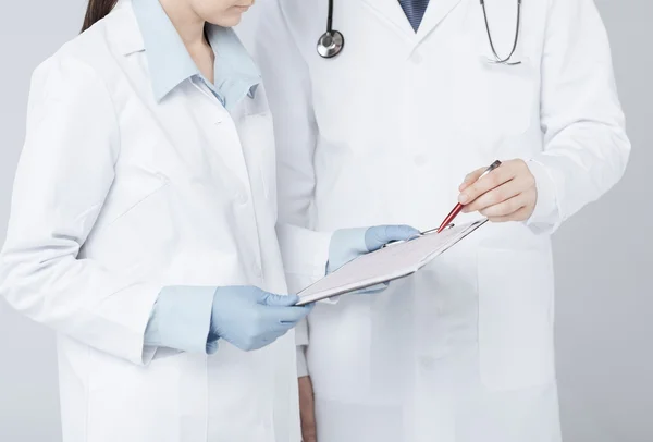 Verpleegkundige en mannelijke arts houden cardiogram — Stockfoto