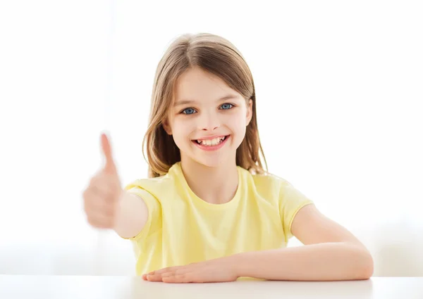 Hermosa niña en casa mostrando los pulgares hacia arriba — Foto de Stock