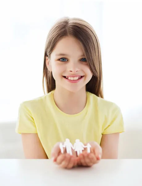 Lächelndes kleines Mädchen zeigt Papiermann-Familie — Stockfoto