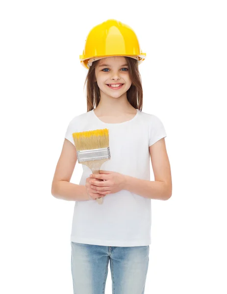 Sorrindo menina no capacete com pincel de tinta — Fotografia de Stock