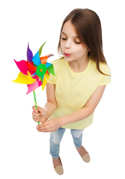 Criança sorridente com brinquedo colorido de moinho de vento — Fotografia de Stock