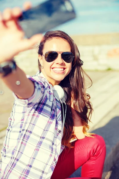 Adolescente sonriente tomando fotos con teléfono inteligente —  Fotos de Stock