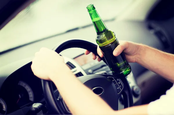 Мужчина пьет алкоголь за рулём автомобиля — стоковое фото