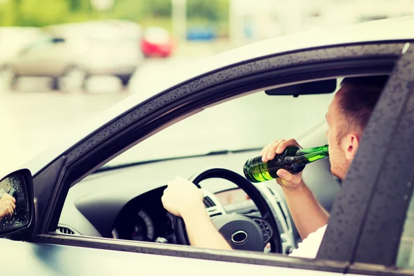 Hombre beber alcohol mientras conduce el coche — Foto de Stock