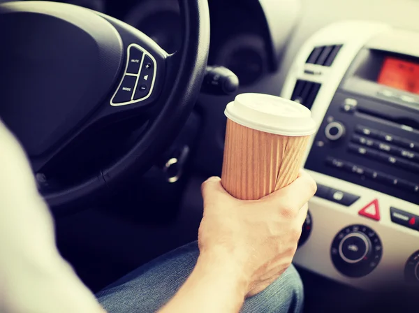 Uomo che beve caffè mentre guida l'auto — Foto Stock