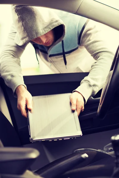 Thief stealing laptop from the car — Stock Photo, Image