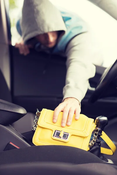 Thief stealing bag from the car — Stock Photo, Image