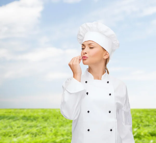 Sorridente chef femminile mostrando delizioso segno — Foto Stock