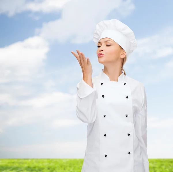 Glimlachend vrouwelijke chef-kok heerlijke teken weergegeven: — Stockfoto