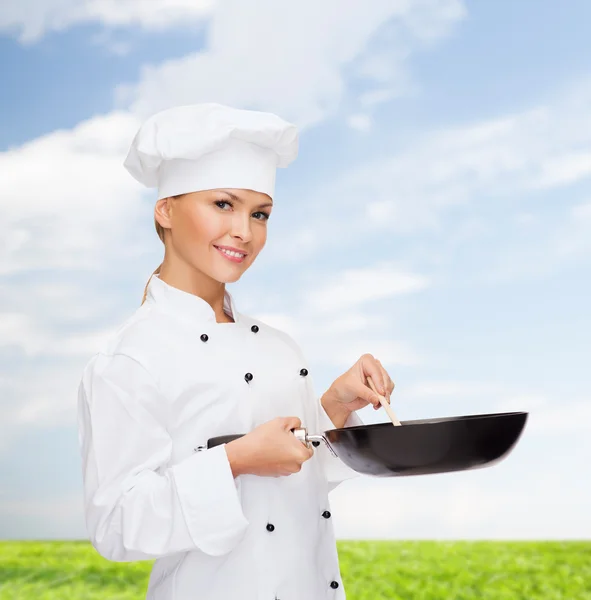 Chef sonriente con sartén y cuchara — Foto de Stock