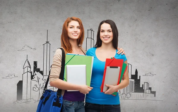 Two smiling students with bag, folders and tablet — Stock Photo, Image