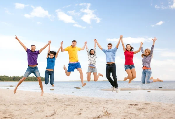 Группа друзей, прыгающих на пляже — стоковое фото