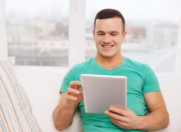 Usmívající se muž pracující s tablet pc doma — Stock fotografie