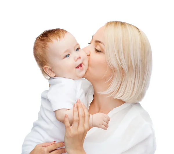 Glückliche Mutter küsst lächelndes Baby — Stockfoto