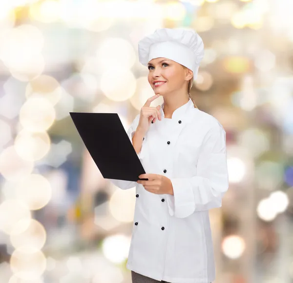 Smiling female chef with black blank paper — Stock Photo, Image