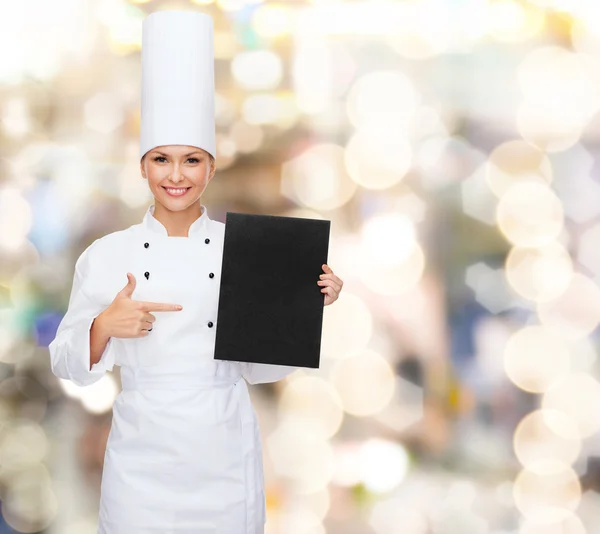 Smiling female chef with black blank paper — Stock Photo, Image