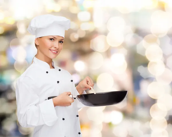 Lachende vrouwelijke chef-kok met pan- en -lepel — Stockfoto