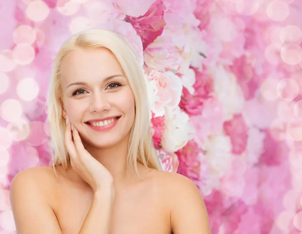 Sonriente joven mujer tocando su cara piel — Foto de Stock