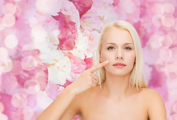 Calm young woman pointing at her cheek — Stock Photo, Image