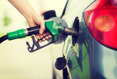 man pumping gasoline fuel in car at gas station clipart