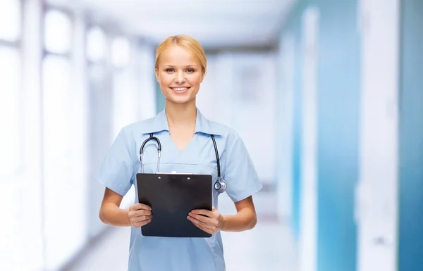 Médico o enfermera sonriente con portapapeles —  Fotos de Stock