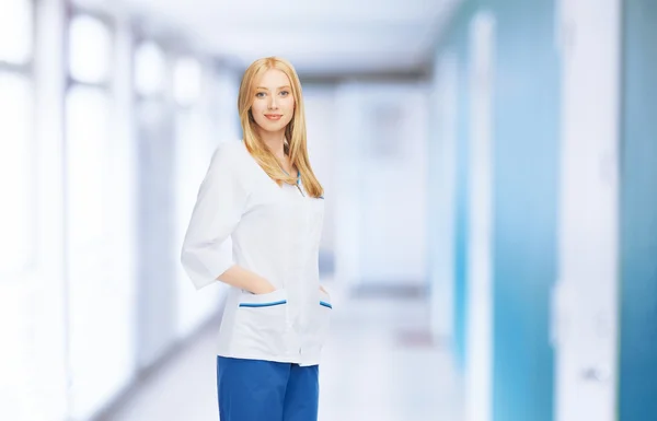 Smiling female doctor or nurse in medical facility — Stock Photo, Image