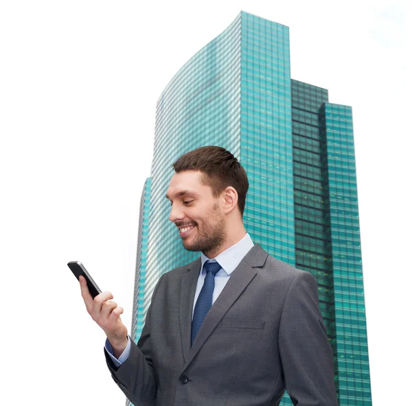 Jovem empresário sorridente com smartphone — Fotografia de Stock