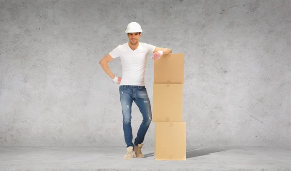 Hombre en casco con torre de cajas de cartón — Foto de Stock