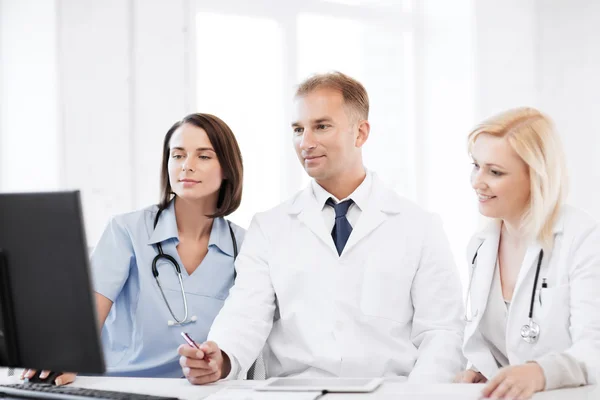 Doctors looking at computer on meeting — Stock Photo, Image
