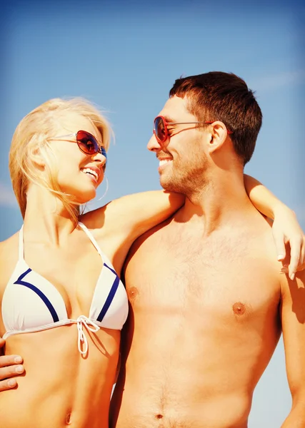 Joyeux couple en lunettes de soleil sur la plage — Photo