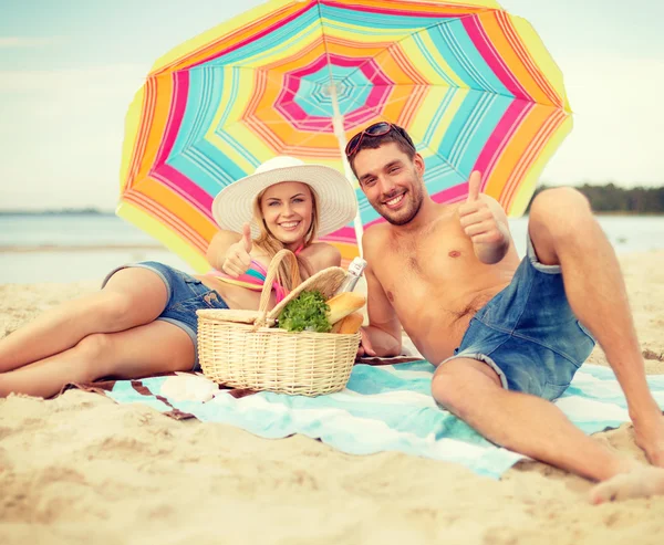 Pareja sonriente tomando el sol en la playa —  Fotos de Stock