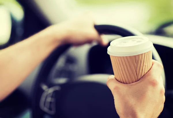 Człowiek pije kawę podczas jazdy samochodem — Zdjęcie stockowe